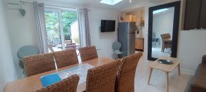 a dining table and chairs in a living room at Les Muguets in Villers-sur-Mer