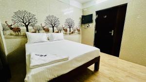 Schlafzimmer mit einem Bett mit Hirschgemälden an der Wand in der Unterkunft Hotel Star Nivas, Srirangam in Tiruchchirāppalli