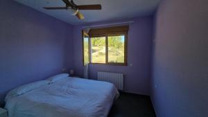 Dormitorio azul con cama y ventana en Casa de la Santa, en Moratalla