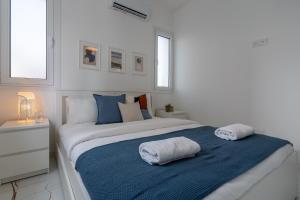 um quarto branco com uma cama grande e toalhas em Artemis 1-Bedroom Apartment in Larnaca em Larnaka