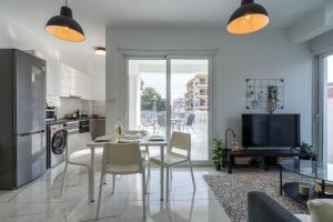 uma cozinha e sala de jantar com uma mesa e uma televisão em Artemis 1-Bedroom Apartment in Larnaca em Larnaka