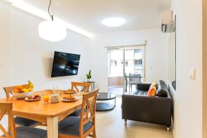 comedor y sala de estar con mesa y sofá en Myflats Premium Arenales Hills en Arenales del Sol