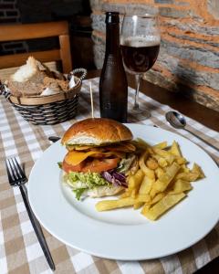 a sandwich and french fries on a plate with a glass of wine at Hotel Aroi Bierzo Plaza in Ponferrada