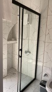 a shower with a glass door in a bathroom at RED FLAG HOTEL in Aksu