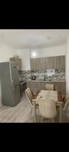 eine Küche mit einem Tisch und Stühlen sowie einem Kühlschrank in der Unterkunft I Love Tirana 3 in Tirana