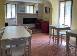 a living room with tables and chairs and a fireplace at Agriturismo SetteLune in Bibbiano