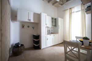 a kitchen with white cabinets and a table and a window at Le dimore delle stelle in Mola di Bari