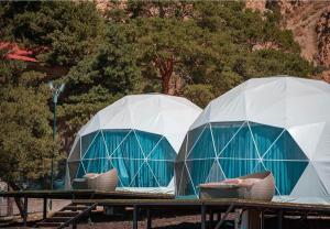 two domed tents sitting on a table with chairs at Comuna Sevan in Artanish