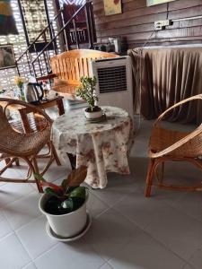 eine Terrasse mit einem Tisch und Stühlen sowie einem Tisch mit einer Pflanze in der Unterkunft บ้านทุ่งโฮมสเตย์ in Ban Chai Khlong