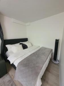 a bedroom with a large bed with white sheets and pillows at Close to the metro and the beach!!! with a view of the Scandinavian forest in Stockholm
