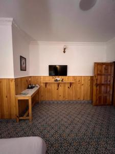 a room with a desk and a tv on a wall at hotel saina inn in Dehradun
