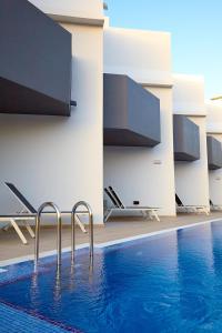 a swimming pool in a building with blue water at ALEGRIA Barranco in Playa de las Americas