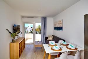 sala de estar con mesa blanca y sillas en ALEGRIA Barranco, en Playa de las Américas