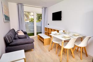 a living room with a couch and a table and chairs at ALEGRIA Barranco in Playa de las Americas