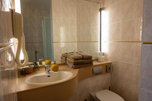 德哈恩的住宿－肯特拉爾酒店，一间带水槽、卫生间和镜子的浴室