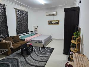 una sala de estar con una cama y un sofá en The New House Hostal, en Mascate