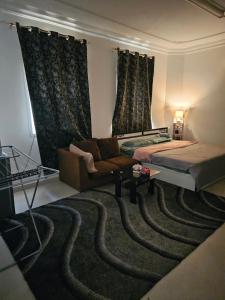 una sala de estar con un sofá y una alfombra en The New House Hostal, en Mascate