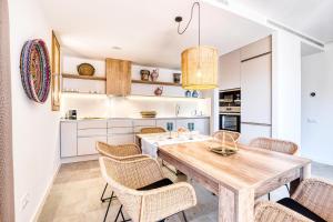 - une cuisine avec une table et des chaises en bois dans l'établissement CAMBRILS Chic! Apartments by ALEGRIA, à Cambrils