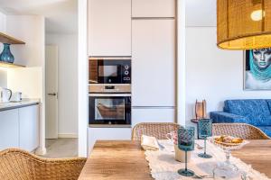 a kitchen and living room with a wooden table and chairs at CAMBRILS Chic! Apartments by ALEGRIA in Cambrils
