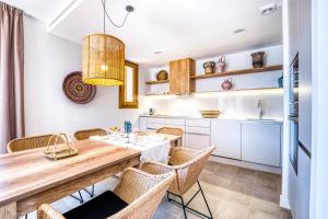 a kitchen with a wooden table and chairs at CAMBRILS Chic! Apartments by ALEGRIA in Cambrils