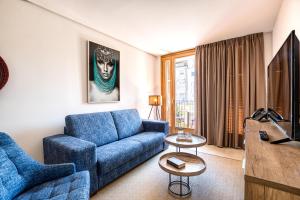 CAMBRILS Chic! Apartments by ALEGRIA في كامبريلس: غرفة معيشة مع أريكة زرقاء وتلفزيون