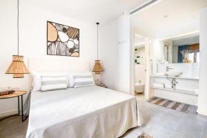 a white bedroom with a bed and a sink at CAMBRILS Chic! Apartments by ALEGRIA in Cambrils