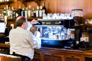 a man standing at a counter with a coffee maker at ALEGRIA Bodega Real in El Puerto de Santa María