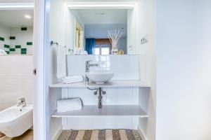 カンブリルスにあるCAMBRILS Chic! Apartments by ALEGRIAの白いバスルーム(洗面台、トイレ付)