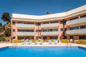un hotel con piscina frente a un edificio en SANTA SUSANNA Chic! Apartments by ALEGRIA, en Santa Susanna