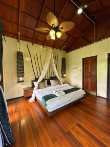a bedroom with a bed with a ceiling fan at Sepilok Forest Edge Resort in Sepilok