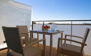 a table with chairs and a bowl of fruit on a balcony at SANTA SUSANNA Chic! Apartments by ALEGRIA in Santa Susanna