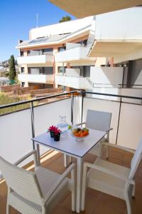 una mesa en un balcón con sillas y un bol de fruta en SANTA SUSANNA Chic! Apartments by ALEGRIA en Santa Susanna