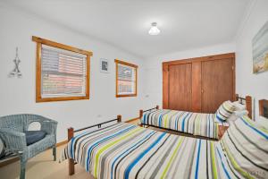 sypialnia z 2 łóżkami i krzesłem w obiekcie Panoramic Views on Walter w mieście Bridport