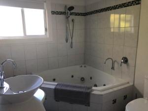 a white bathroom with a tub and a sink at Panoramic Views on Walter in Bridport