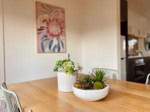 a dining room table with two potted plants on it at 2B house with private entry free parking 4mins to Airport in Melbourne