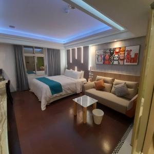 Habitación de hotel con cama y sofá en King Motel王者 en Taoyuan