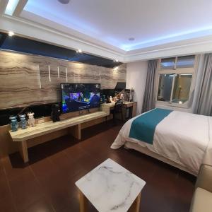 a bedroom with a bed and a flat screen tv at King Motel王者 in Taoyuan