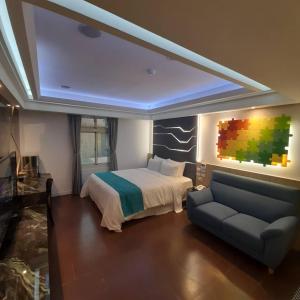 a bedroom with a bed and a couch in it at King Motel王者 in Taoyuan