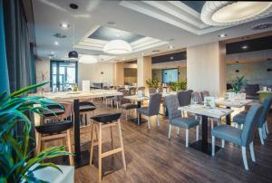 a restaurant with tables and chairs in a room at R31 Residence in Sárvár