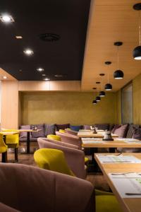 a restaurant with tables and yellow chairs and tablesktop at R31 Residence in Sárvár +45 photos