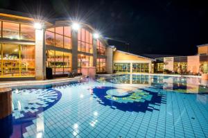 uma grande piscina num edifício à noite em R31 Residence em Sárvár