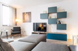 a living room with a couch and a tv at Homefy Altstadt Apartment für 6 Personen, mit 2 Bädern und Balkon in Düsseldorf