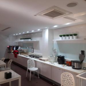 a kitchen with white counters and white chairs in it at King Motel王者 in Taoyuan