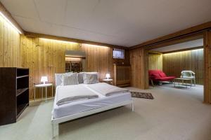 a bedroom with a white bed and a red chair at Gipfelblick Residenz #1 in Kitzbühel