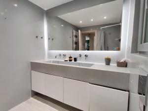 een witte badkamer met een grote wastafel en een spiegel bij WSD New Cosy & Stylish 1BD Apartment Near Metro in Athene