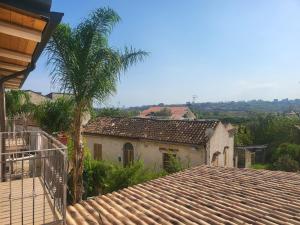 una casa con techo de baldosa y palmera en Vista Allaro, en Caulonia