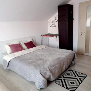 a bedroom with a large bed with red pillows at Family Apartments Dorobok in Lviv