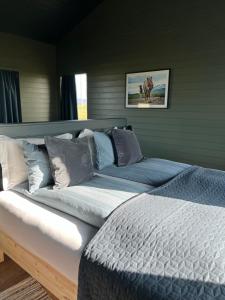 um quarto com uma cama grande e lençóis azuis em Sleeping with the Horses em Hvolsvöllur