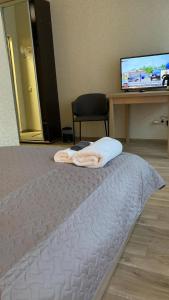 a bedroom with a bed with a desk and a television at Neiroprakse Mini Hotel in Daugavpils