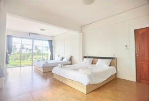 a bedroom with two beds and a large window at 115 Townhouse in Ban Khlong Krang +81 photos